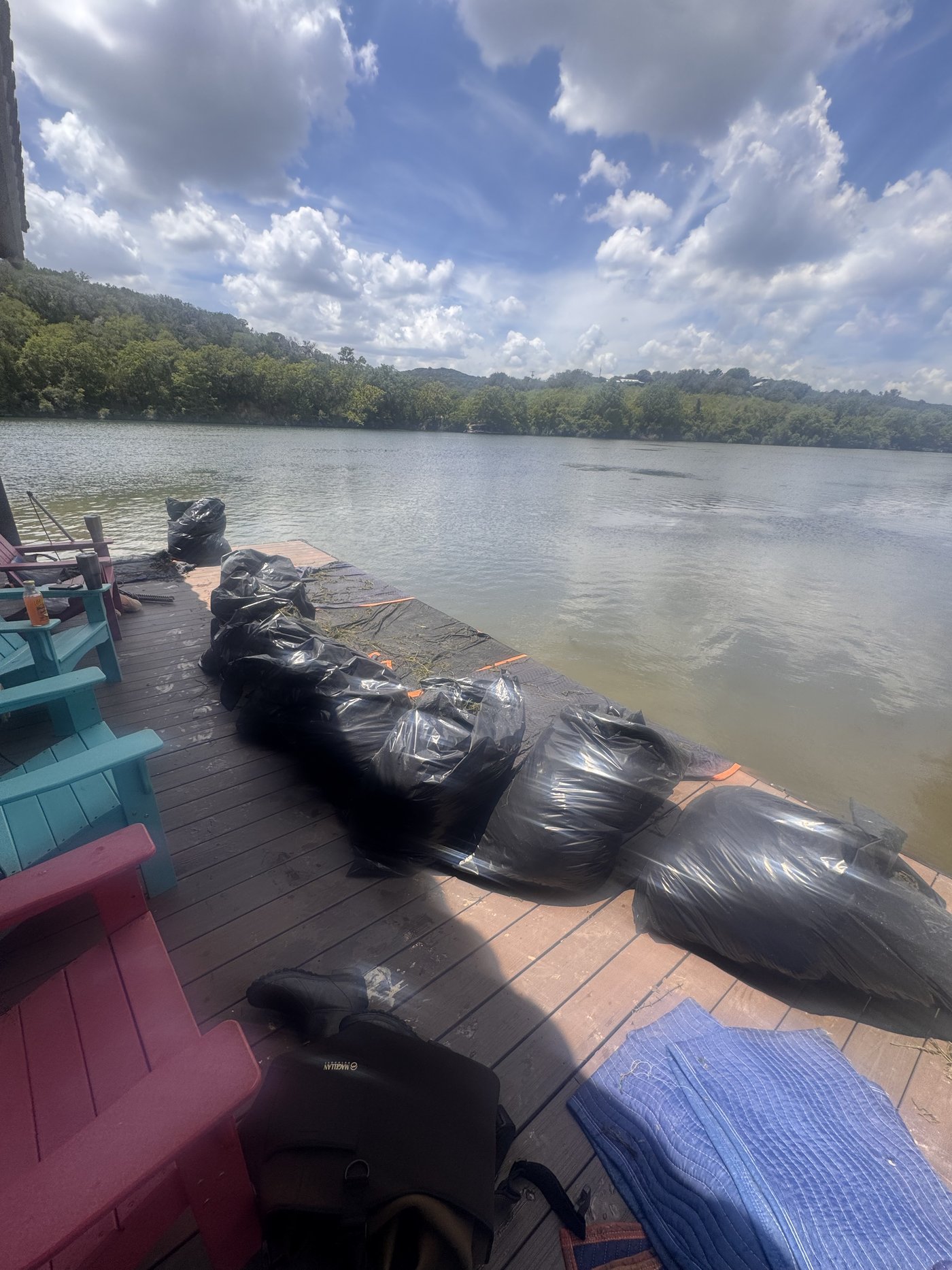 Bags of removed hydrilla piled on a Lake Austin dock after removal